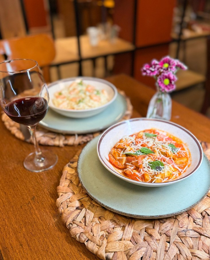 Nhoque ao sugo e risoto servidos com vinho na casa do Vírgula